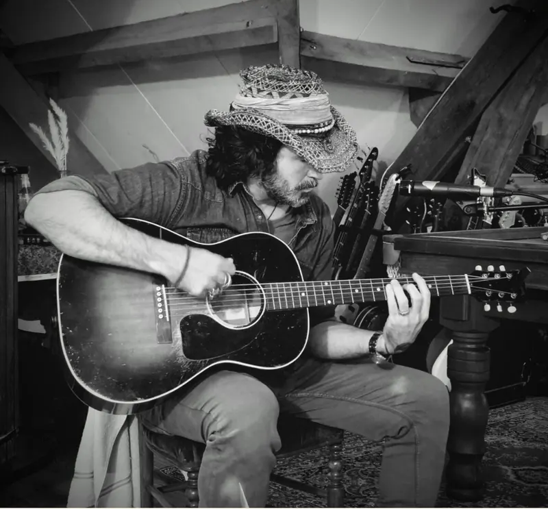 Matt DeHarp à la guitare, en noir et blanc.